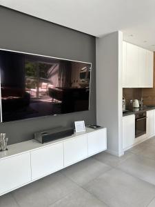a kitchen with a large flat screen tv on a wall at Apartament Dwie Sosny Patrycja in Ustronie Morskie