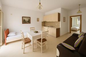 a kitchen and a living room with a table and chairs at 360° View Apartments in Vlorë