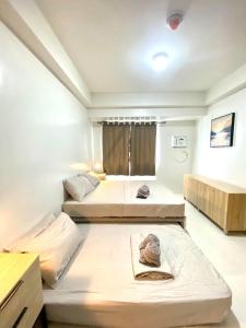 a room with three beds and a window at Premium East Gate 1BR unit in Cebu City