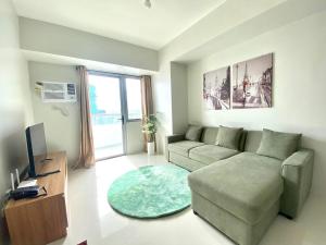 a living room with a couch and a television at Premium East Gate 1BR unit in Cebu City +4 photos