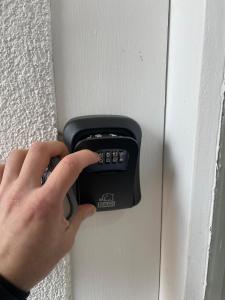 a person holding a remote control on a door at AVIZJA Living in Korneuburg
