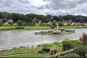 a boat on a river with people on it at Charmante Ferienwohnung 2 im Schmöllerhäuschen in Stadt Wehlen
