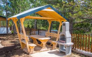 a wooden gazebo with a table and a stove at Natural Dream Blidinje in Rudo Polje