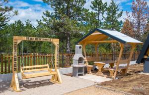 a playground with a bench and a gazebo at Natural Dream Blidinje in Rudo Polje +83 photos