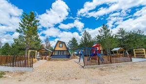 a playground with a house and a swing at Natural Dream Blidinje in Rudo Polje