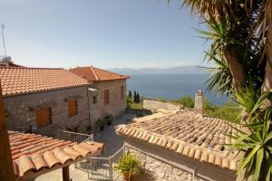 an image of a house with a view of the ocean at Fteri Stone House in Platanos, Akrata in Plátanos