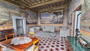 a dining room with a table and a painting on the wall at Castello Bonaccorsi in Sabina in Castel San Pietro