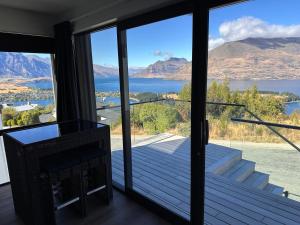 a room with a view of the water and mountains at 1Queenstown - Stunning Lake and Mountain Views in Queenstown