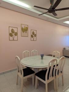 a dining room table with chairs and a ceiling fan at One Family Homestay Kulim in Kulim