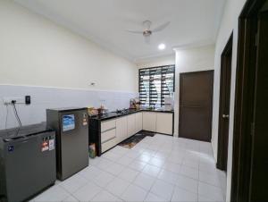 a large kitchen with a counter and a refrigerator at One Family Homestay Kulim in Kulim +5 photos