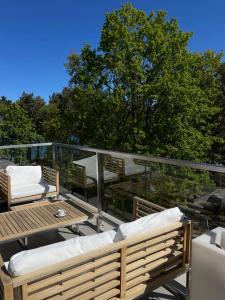 a deck with chairs and a table on a balcony at Apartament Dwie Sosny Patrycja in Ustronie Morskie