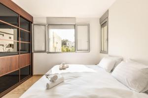 سرير أو أسرّة في غرفة في Chic Apartment w Balcony & Parking 3-min from Beach with Mamad by Sea N' Rent