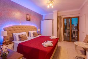 a bedroom with a large bed with a red blanket at Knights' Castle Studios in Archangelos