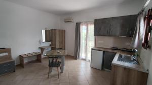 a kitchen with a table and a sink and a table at Smaragda Hotel in Marathokampos