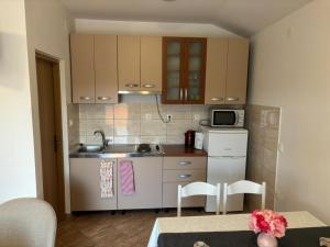 a small kitchen with a sink and a microwave at Apartment & Studio Vrdoljak in Sveti Anton