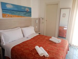 a hotel room with a bed with two towels on it at Hotel Adriana in Bellaria-Igea Marina