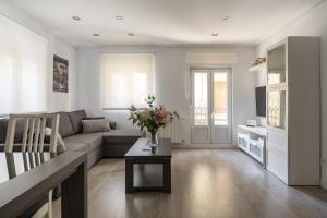 Una sala de estar con un sofá y una mesa con flores. en Apartment Atalaya in the center, en Santander