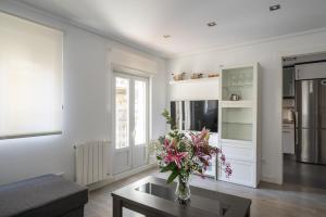 Una sala de estar con un jarrón de flores sobre una mesa. en Apartment Atalaya in the center, en Santander