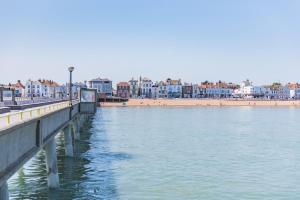 a pier next to a beach with buildings in the background at Strand Apartment by Keepers Cottages in Deal