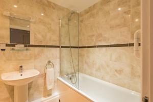 a bathroom with a tub and a sink and a shower at Strand Apartment by Keepers Cottages in Deal +15 photos