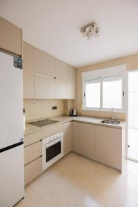 Una cocina con gabinetes blancos y un fregadero. en un lujo a 2 min de la playa, en Pilar de la Horadada