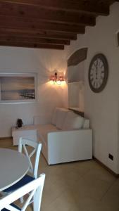 a living room with a white couch and a clock at nel cuore di sestri in Sestri Levante