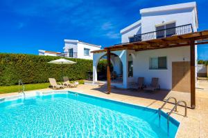 a swimming pool in front of a villa at Villa Christina in Argaka