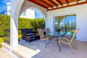 a patio with a table and chairs and a couch at Villa Christina in Argaka