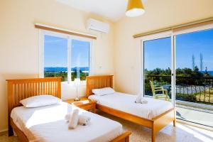 two beds in a room with a balcony at Villa Christina in Argaka +23 photos