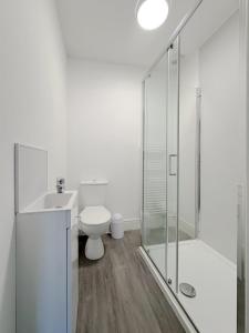 a white bathroom with a toilet and a shower at Nelson Road North in Great Yarmouth