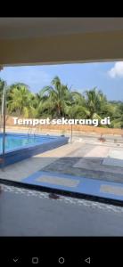 - une vue sur la piscine avec des palmiers en arrière-plan dans l'établissement Homestay Islam Nurqaseh Masjid Tanah Melaka, à Masjid Tanah