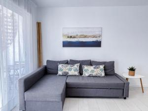 a living room with a gray couch with pillows at NUEVO, a 70 metros de la playa y con vistas al mar in Cullera