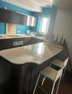 eine Küche mit einer Theke und zwei Stühlen darin in der Unterkunft Private Room in sharing apartment CENTRAL MALTA in Sliema
