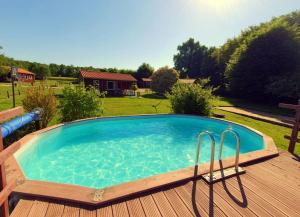 a large plunge pool on a deck with a wooden deck at Les Chalets du Quignon in Autry-le-Châtel