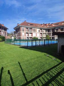 a building with a swimming pool in front of a yard at Pura Vida Apartmento in Ramales de la Victoria +9 photos