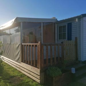 a house with a deck with a cover on it at Mobil-home à 500m des mégalithes in Carnac