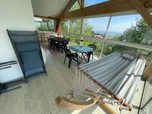 a screened in porch with a hammock and a table and chairs at Évasion en Ardèche villa de Charme avec Piscine in Saint-Romain-de-Lerps