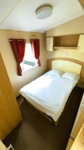 a bedroom with a large white bed with a window at Alex Domki Angielskie Taras Widokowy in Rewal