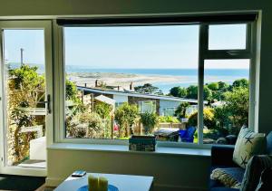 a living room with a large window looking out at the beach at Ynyslas View in Aberdyfi