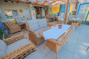 eine Terrasse mit Korbmöbeln, einem Tisch und Stühlen in der Unterkunft FrauGULER in Amasra