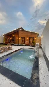 a house with a swimming pool in front of a house at كوخ سترين in Tabuk