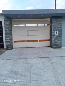 a garage with two white garage doors on a building at La kasita in Paraná