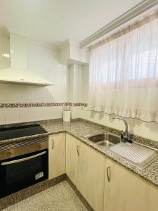 a small kitchen with a sink and a window at Apartamento Playa Torreón in Benicàssim +24 photos