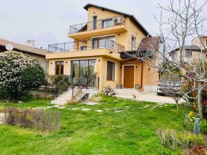 a large yellow house with a yard in front of it at Modern Villa with Garden in Evksinograd, Varna by Flat manаger in Varna City