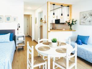 ein kleines Wohnzimmer mit einem weißen Tisch und Stühlen in der Unterkunft Live Punta Columbus Pool & Beach Front in Punta del Hidalgo + 26 Fotos