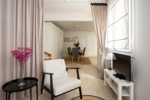 a living room with a white chair and a table at Apartamento Vargas 2BDR in Santander