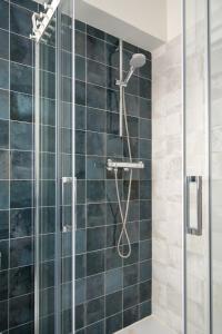 a bathroom with a shower with blue tiles at Apartamento Vargas 2BDR in Santander +33 photos