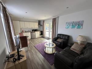 a living room with a couch and a table at Dainville Retreat in Skegness
