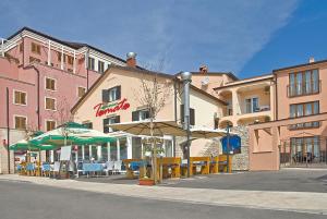 restauracja ze stołami i parasolami przed budynkiem w obiekcie Apartments Tomato w mieście Novigrad