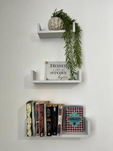 a book shelf with books and a plant on it at The Failsworth Collection - Stylish Apartments with Free Parking in Manchester
